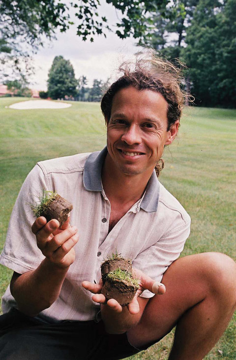 Daniel Peck holding turf samples on a golf course