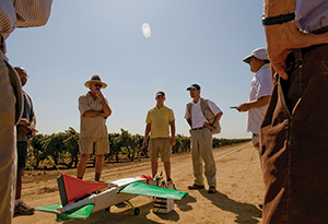 People in field with a drone aircraft