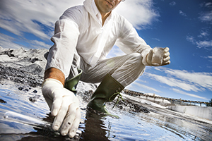 A scientist samples water for testing.